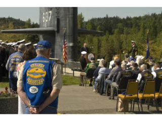 Guests bow their heads at a tolling of the boats ceremony held at the Naval Undersea Museum