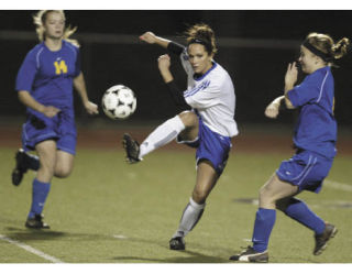 Olympic’s Ali Brown drives a shot between two Bremerton defenders Tuesday night at Silverdale Stadium. Brown scored the game-winning goal in the 77th minute to give the Trojans the win. Bremerton dropped to 4-6 in league play.