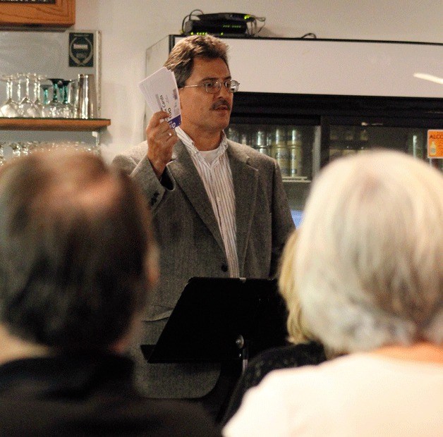 North Kitsap Herald Editor Richard Walker reads audience questions to Port of Kingston candidates Bruce MacIntyre and Nels Sultan at a forum held at the Kingston Community Yacht Club.