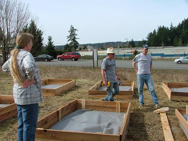 Poulsbo Fire personnel donate their time and resources to build a raised bed: from left Office Manager Sue Gibbs