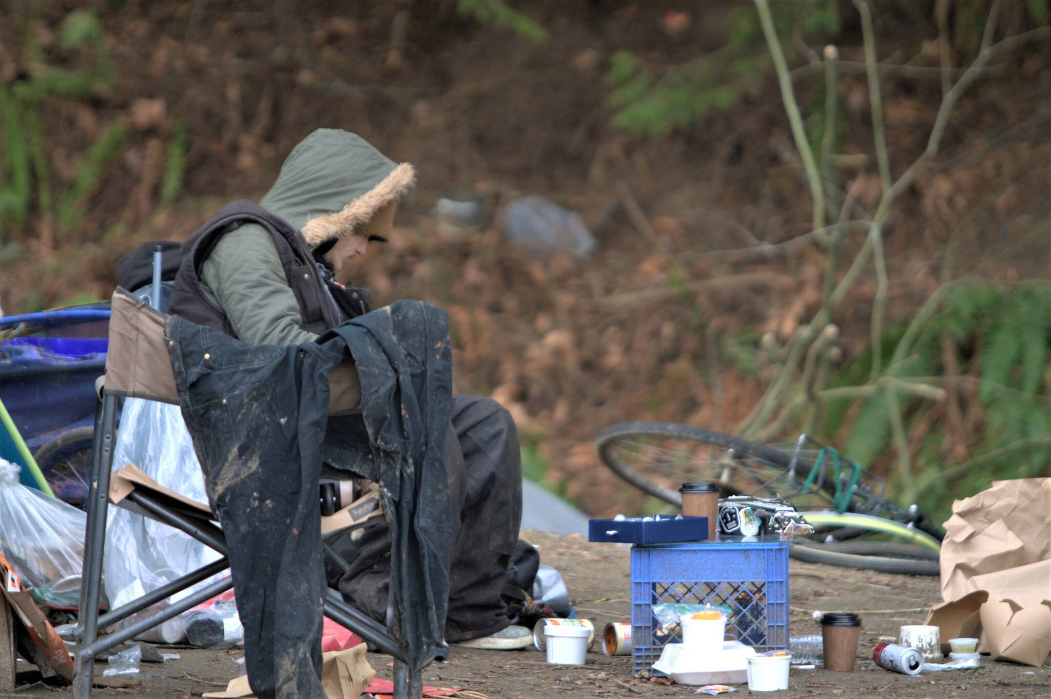 A homeless person sits among the filth of the camp along Bethel Avenue. Elisha Meyer/Kitsap News Group Photos