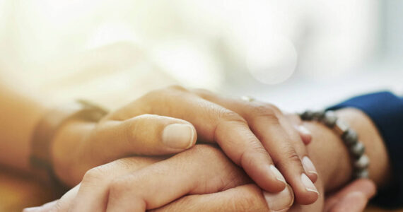 Closeup shot of two unrecognizable people holding hands in comfort