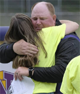 Damon Williams/Kitsap News Group photos
Head North Kitsap High School football coach Jeff Weible gets a hug at the memorial for one of his assistant coaches, Dave Snyder, who died recently while the team was at a camp in Ellensburg.