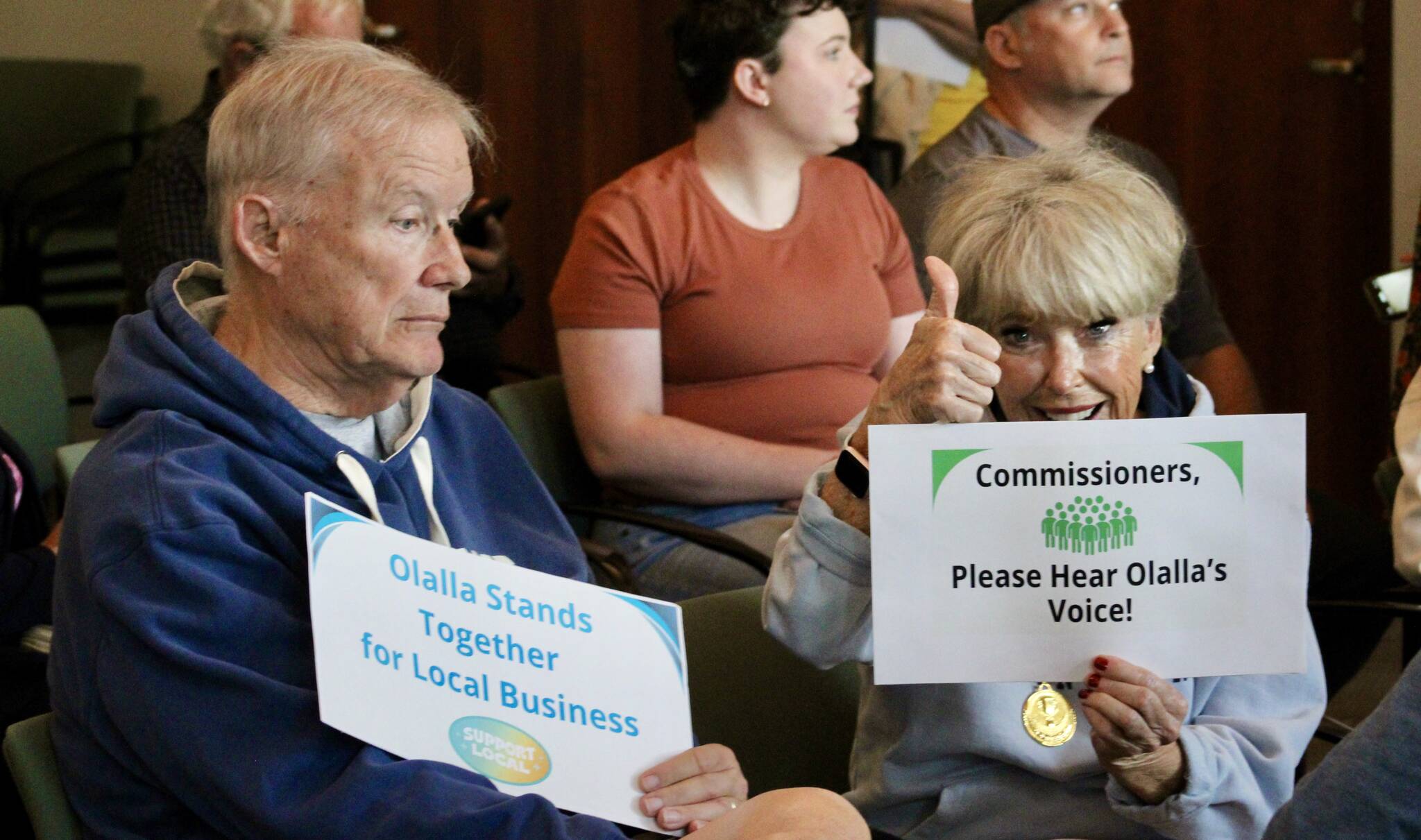 Elisha Meyer/Kitsap News Group photos
Sunny Willson, right, an employee of the Olalla Bay Market, shows her support for the Olsens at the Aug. 12 meeting of the Kitsap Board of Commissioners.