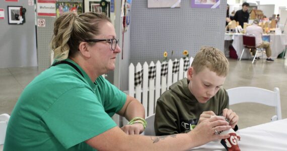 Elisha Meyer/Kitsap News Group photos
Seisha Hassett sits with her son Timothy, who is hard at work sewing fabric together at the Kitsap Fair and Stampede.