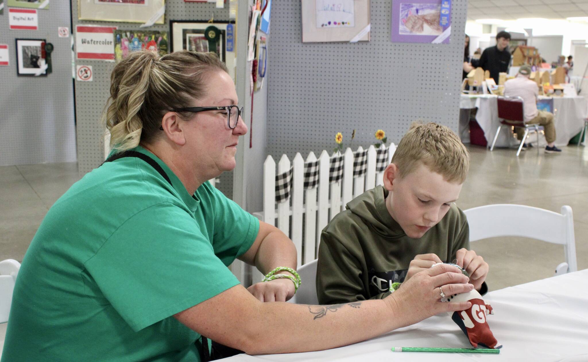 Elisha Meyer/Kitsap News Group photos
Seisha Hassett sits with her son Timothy, who is hard at work sewing fabric together at the Kitsap Fair and Stampede.