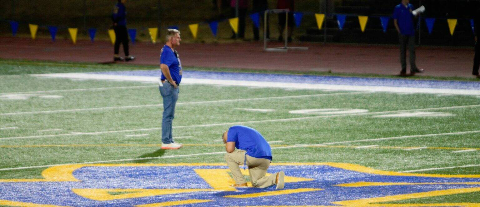 File photo
Former assistant football coach Joe Kennedy prays at midfield in his first and only game back on the coaching staff at Bremerton High School in 2023. He resigned just days later.