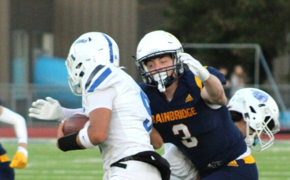 Elisha Meyer/Kitsap News Group photos
Bainbridge senior Adrian Ayling goes in for a tackle against a scrambling Olympic quarterback Antonio Castorena.