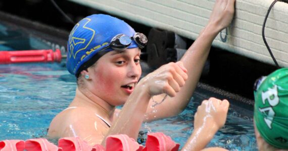 Elisha Meyer/Kitsap News Group
Bremerton swimmer Gabbie Patti offers a fist bump to a Port Angeles swimmer after finishing the 100-yard backstroke.