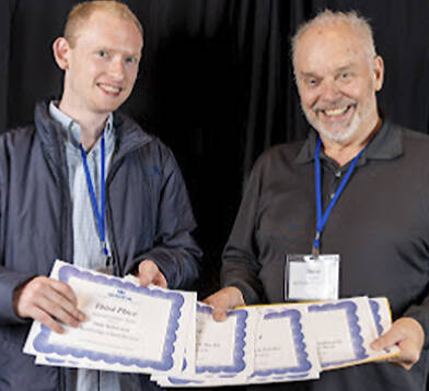 WNPA courtesy photo
Tyler Shuey and Steve Powell pick up the awards won by Bainbridge Island Review staff.