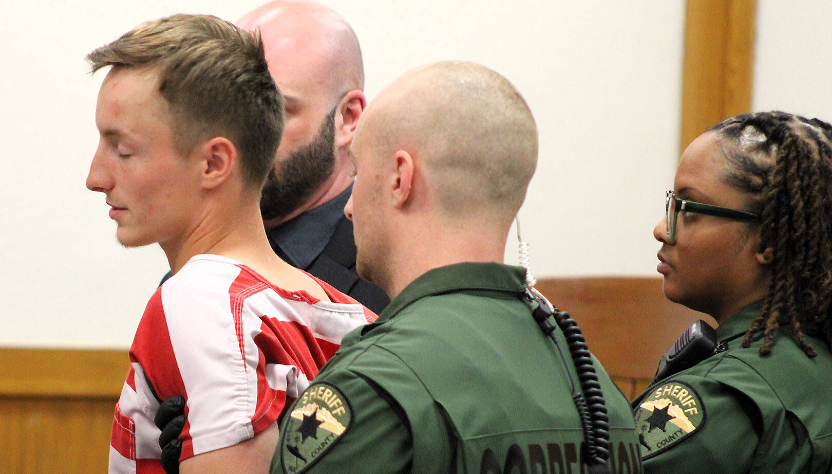 Elisha Meyer/Kitsap News Group
23-year-old double homicide suspect Seth South is restrained by shackles and a trio of correction officers in court Oct. 10. Officers began to accompany him before the judge after he made a sudden move toward the gallery of the courtroom.