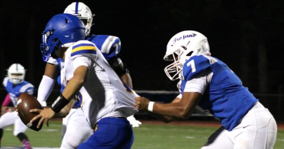 Elisha Meyer/Kitsap News Group photos
Olympic senior linebacker Gabriel Happili tugs on the jersey of Bremerton quarterback Anthony Medina.