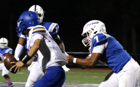 Elisha Meyer/Kitsap News Group photos
Olympic senior linebacker Gabriel Happili tugs on the jersey of Bremerton quarterback Anthony Medina.