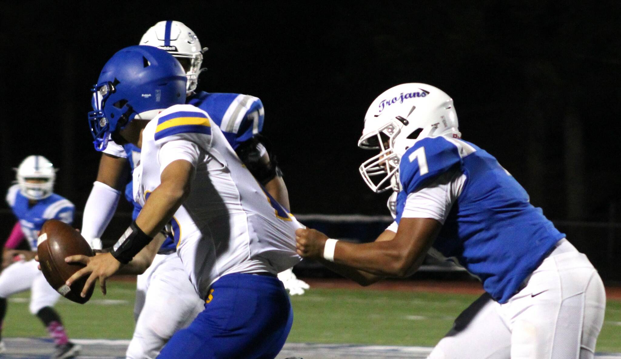 Elisha Meyer/Kitsap News Group photos
Olympic senior linebacker Gabriel Happili tugs on the jersey of Bremerton quarterback Anthony Medina.