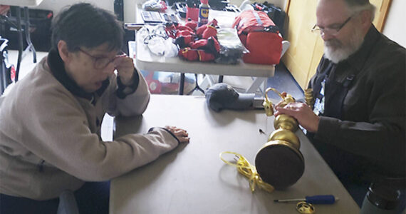 Mark Storer/Kitsap News Group photos
Gary Beanland tries to repair an antique lamp Sharon Witt brought in to have fixed.