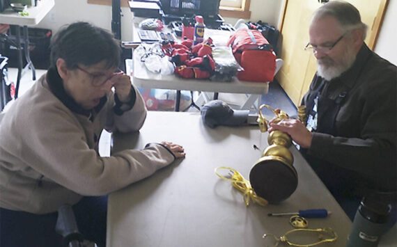 Mark Storer/Kitsap News Group photos
Gary Beanland tries to repair an antique lamp Sharon Witt brought in to have fixed.