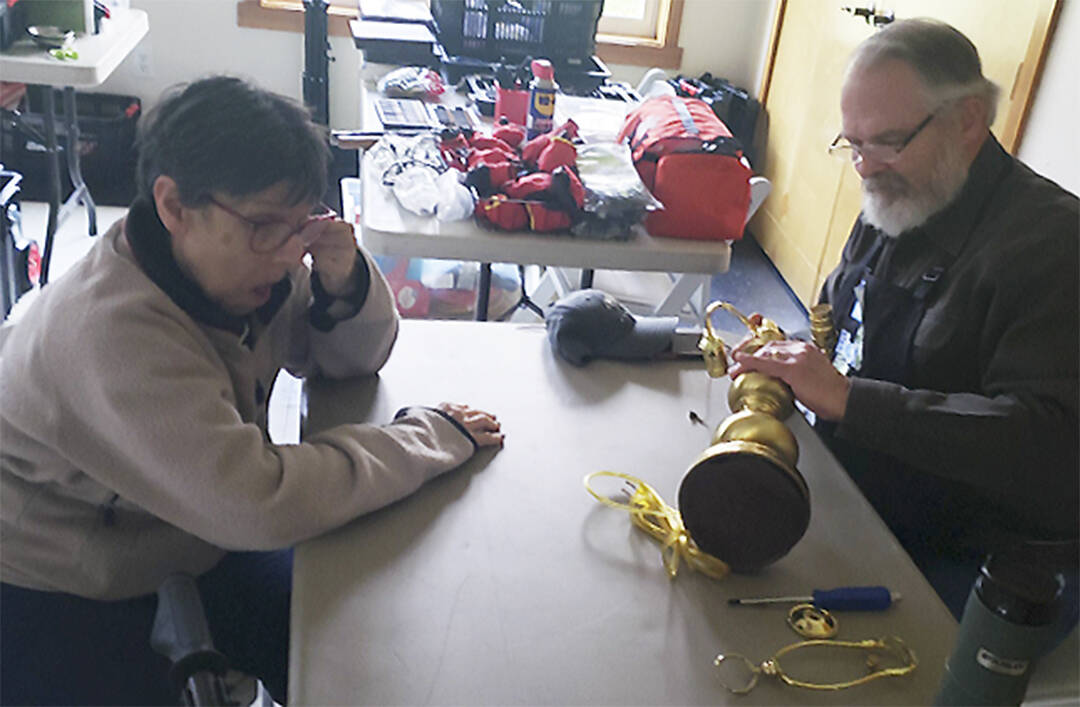 Mark Storer/Kitsap News Group photos
Gary Beanland tries to repair an antique lamp Sharon Witt brought in to have fixed.